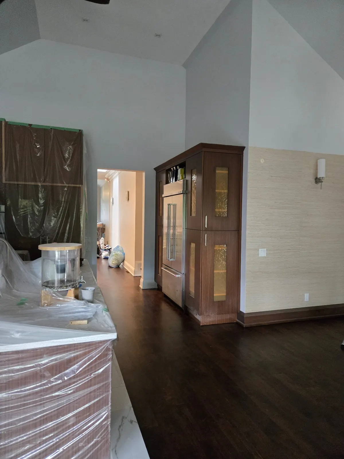 Main floor overview showing protected furniture areas and construction dust spread across the space