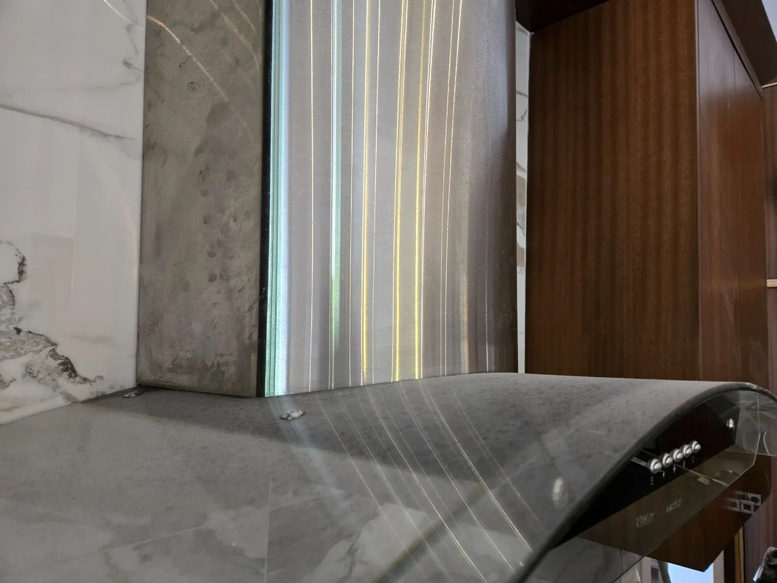 Close-up of range hood showing fine construction dust accumulation on surface detail