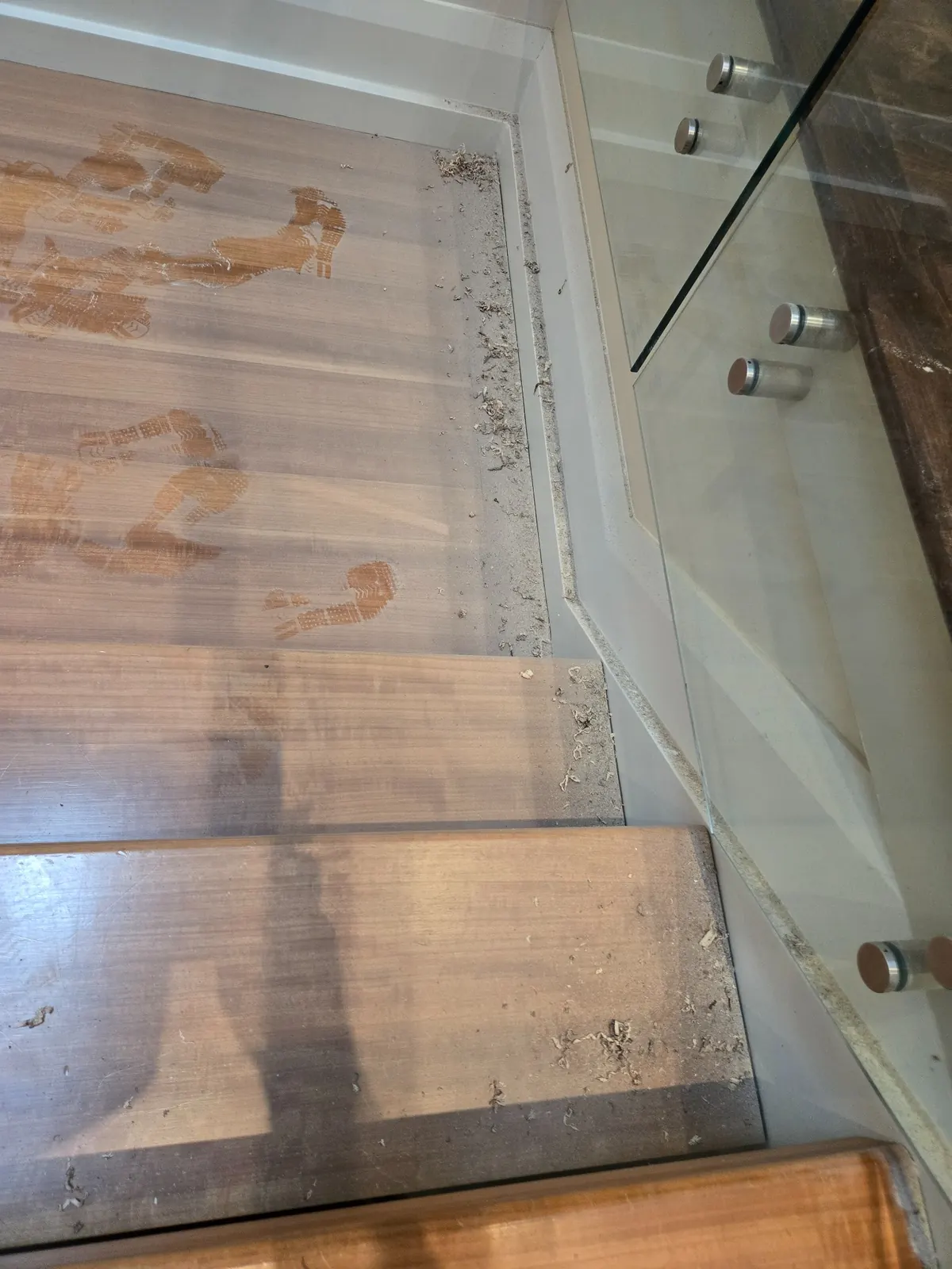 Stair edge showing construction debris and fine dust accumulation along step detail