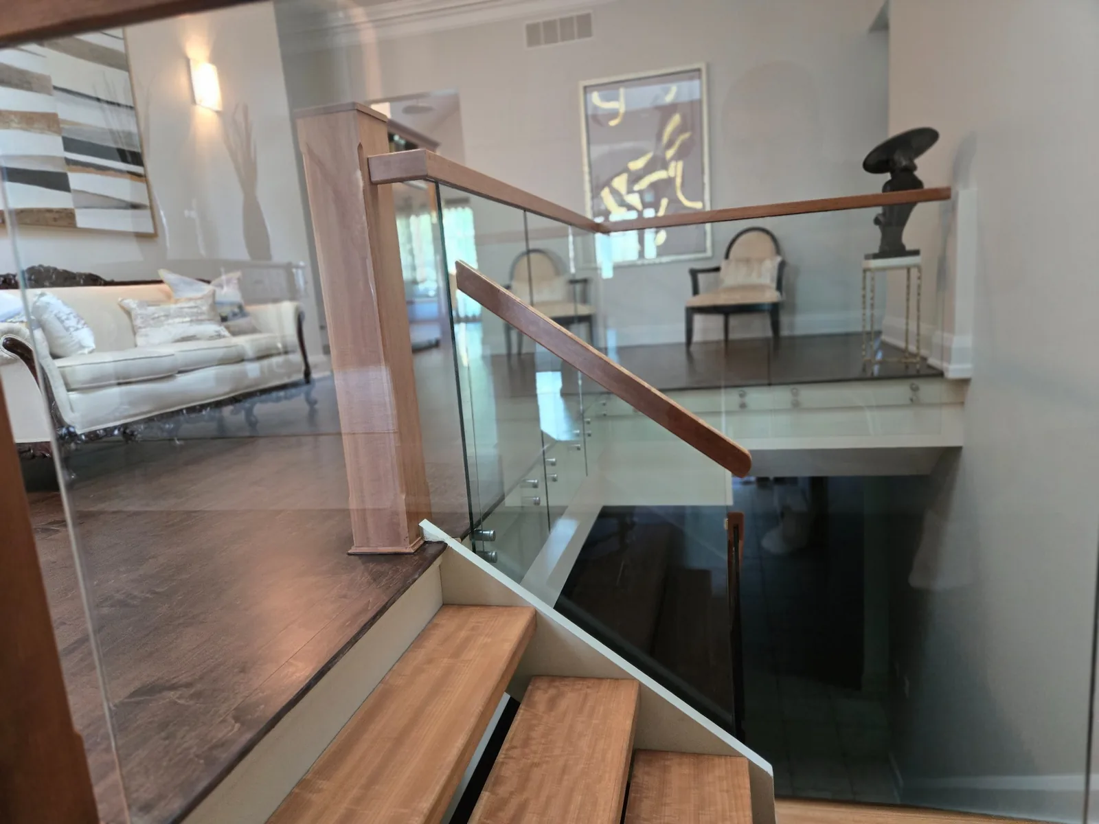 Stairs with glass railing after renovation cleaning — steps, risers, glass panels, and metal hardware cleaned and polished